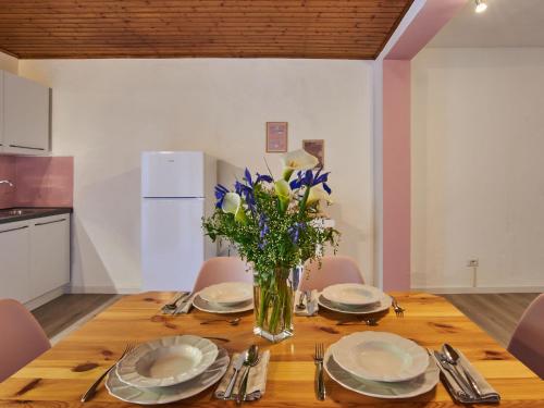 a dining room table with plates and a vase of flowers at Apartment Ca' Dolce Osteno by Interhome in Claino
