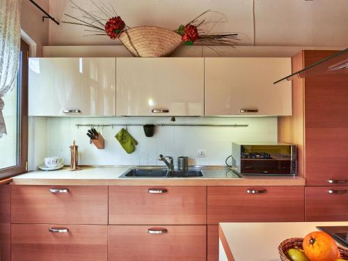 a kitchen with wooden cabinets and a sink at Holiday Home Casa Grandola-Green Garden by Interhome in Naggio