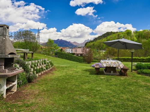 a picnic table with an umbrella in a yard at Holiday Home Casa Grandola-Green Garden by Interhome in Naggio