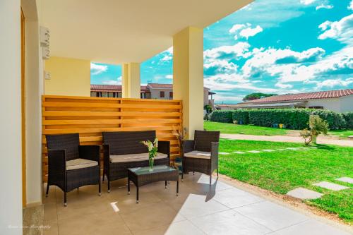 a patio with a table and chairs and a yard at Stella Marina Budoni in Budoni