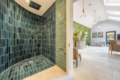 a bathroom with green tiled walls and a walk in shower at The Farmhouse, Nether Hall Estate in Pakenham