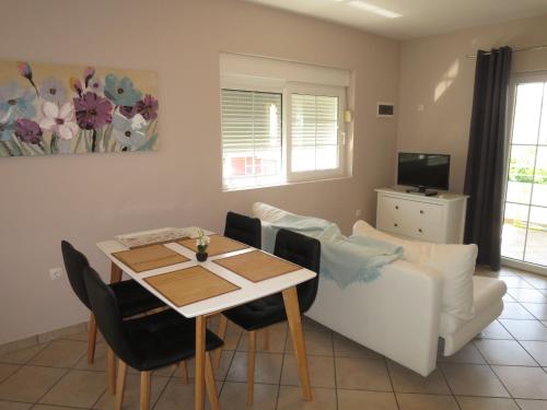 a dining room with a table and chairs at Apartment Tino-3 by Interhome in Sukošan