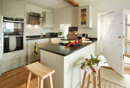 a kitchen with white cabinets and a black counter top at Unconformity Barn in Hope Bowdler