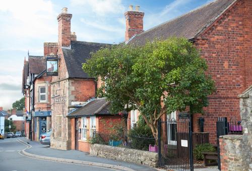 a brick building with a tree in front of it at Unconformity Barn in Hope Bowdler