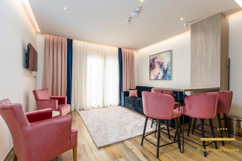 a living room with a table and pink chairs at Hotel Vila Hedonija in Herceg-Novi