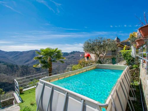 a swimming pool on top of a house with mountains in the background at Holiday Home Kenzo by Interhome in Casabasciana
