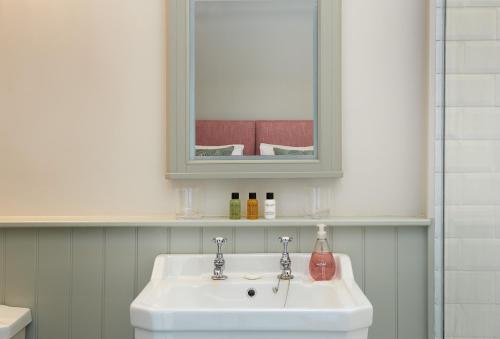 bagno con lavandino bianco e specchio di The Groom's Flat a Leominster