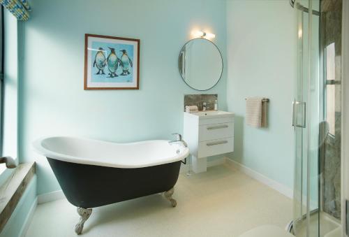 a bathroom with a black and white bath tub and a sink at Evenwood Gables in Kenley