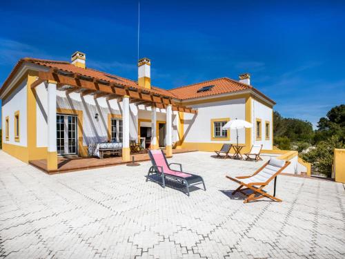 a house with two chairs on a patio at Holiday Home Vista Panorâmica- Herdade de Montalvo by Interhome in Alcácer do Sal