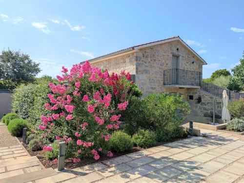 a bush with pink flowers in front of a building at Holiday Home Jerini The Barn by Interhome in Vrh