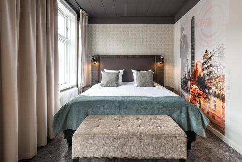 a bedroom with a bed and a large window at Hotel Mayfair in Copenhagen