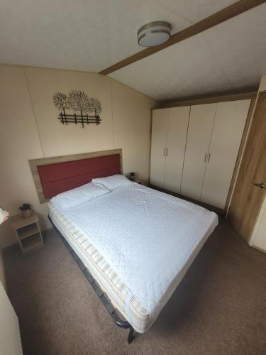 1 dormitorio con 1 cama blanca grande y cabecero rojo en 188 Holiday Resort Unity Brean - Central Location Pet Stays Free - Passes included No workers sorry en Brean