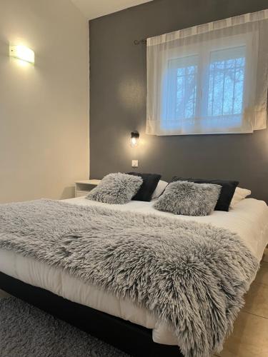 a bedroom with a large bed with a window at La Villa Rapha'elle in Saint-Raphaël