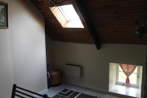 Cette chambre dispose de deux fenêtres et d'un plafond en bois. dans l'établissement Lavender Cottage, à Huelgoat