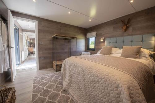 a bedroom with a large bed and wooden walls at Mallard House Lodge in Culgaith