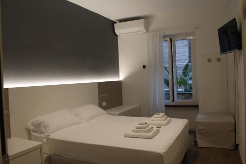 a bedroom with a bed with two towels on it at Albergo Augusta B&B in Camogli