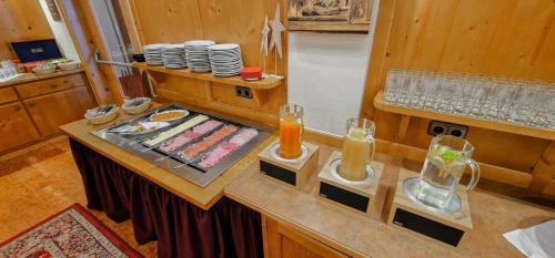 a kitchen with a counter with glasses and plates at Das Alpin - Hotel Garni Guesthouse in Scheffau am Wilden Kaiser
