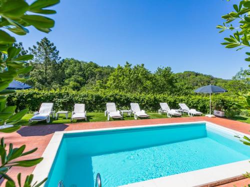 uma piscina com espreguiçadeiras e cadeiras ao lado de um resort em Holiday Home Villa Francesca by Interhome em Montegabbro
