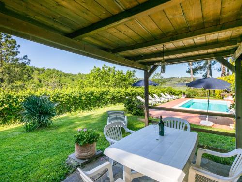 une terrasse avec une table, des chaises et une piscine dans l'établissement Holiday Home Villa Francesca by Interhome, à Montegabbro