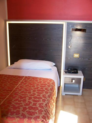 a hotel room with a bed and a night stand at Hotel Carancini in Salsomaggiore Terme