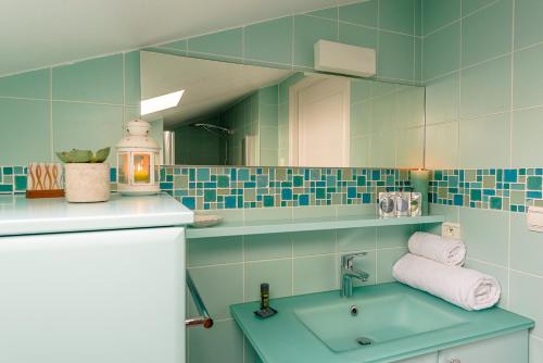 y baño con lavabo y espejo. en L'Hermitage, 4 appartements avec terrasse, vue lac, parking et PISCINE, LLA Selections by Location Lac Annecy, en Talloires