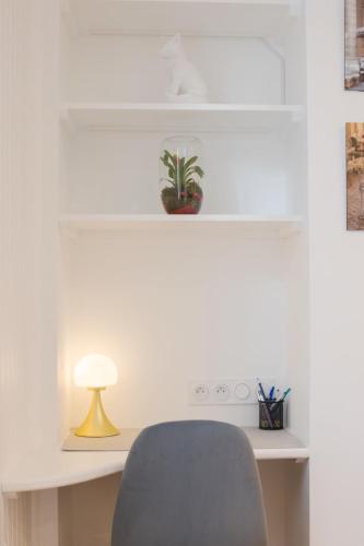 un bureau avec une chaise bleue et une lampe dans l'établissement Appartement confortable 1BR-4P - Boulogne-Billancourt, à Boulogne-Billancourt