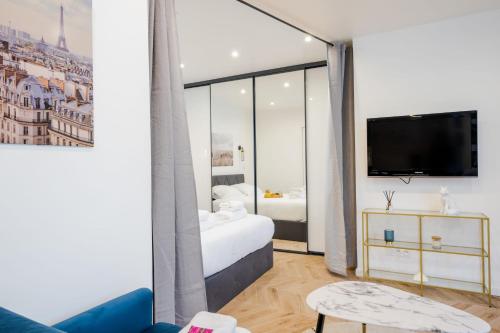 a hotel room with a bed and a tv at Charming apartment completely renovated Boulogne Billancourt in Boulogne-Billancourt