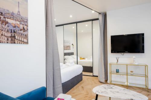 une chambre d'hôtel avec un lit et une télévision dans l'établissement Appartement confortable 1BR-4P - Boulogne-Billancourt, à Boulogne-Billancourt