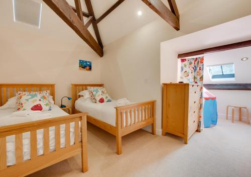a bedroom with two beds and a window at High Mill in Beadnell