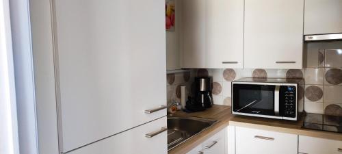 eine Küche mit einer Spüle und einer Mikrowelle in der Unterkunft SEAVIEW STUDIO WESTCLIFF in Blankenberge