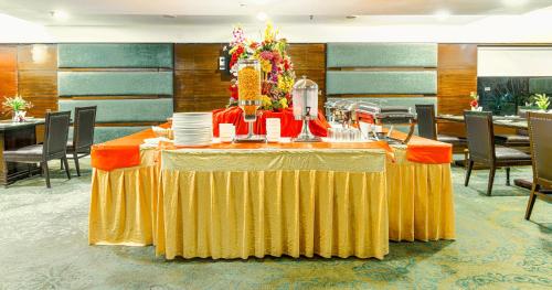 a table in a restaurant with a yellow table cloth at Gis Select Banjara Hill in Hyderabad