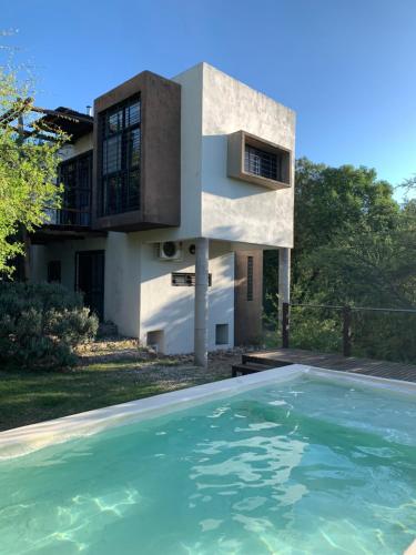 a house with a swimming pool in front of a house at La Molicie, Achiras Arriba in San Javier