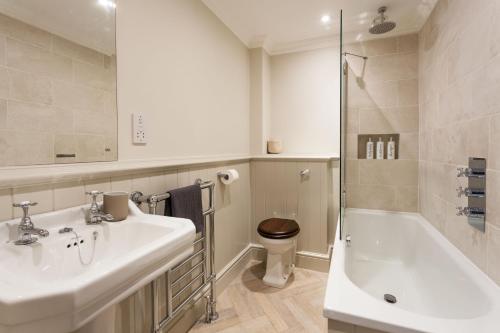 a bathroom with a sink and a tub and a toilet at East House in Pickmere