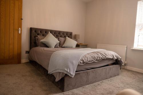 um quarto com uma cama grande e almofadas brancas em Rose Cottage em Shrewsbury