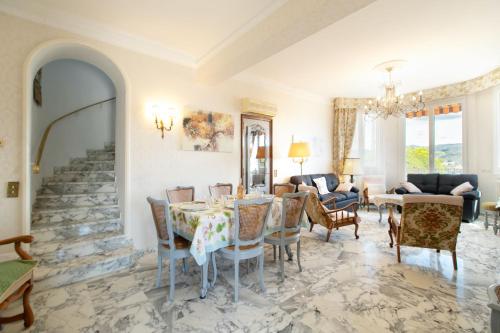 un salon avec une table et des chaises dans l'établissement Maison Bianchi - Villa Saint Pierre de Feric, à Nice