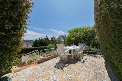 une table et des chaises assises sur une terrasse en pierre dans l'établissement Maison Bianchi - Villa Saint Pierre de Feric, à Nice