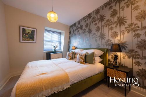 1 dormitorio con 1 cama grande y papel pintado tropical en Super Vibrant 2 Bedroom With Parking, en Maidenhead