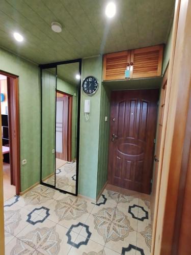 a hallway with a door and a clock on the wall at Mieszkanie Jelenia in Jelenia Góra