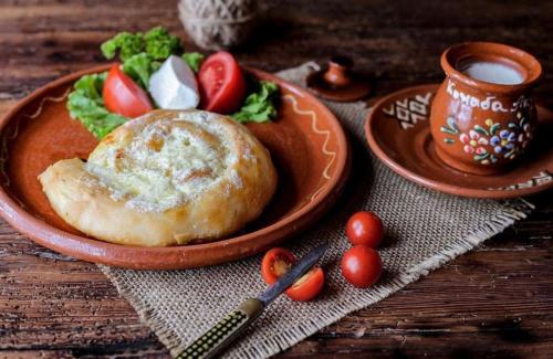 a plate of food with tomatoes and a salad on a table at Hotel Konačište Akustik in Zlatibor