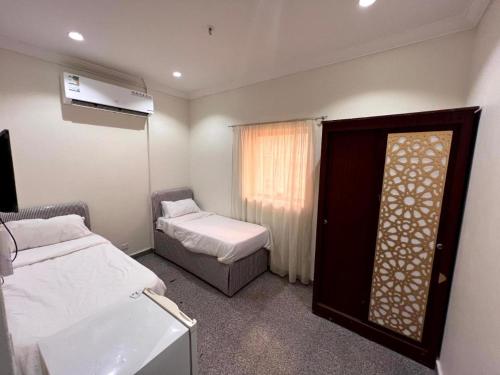 a small room with two beds and a window at فندق الفيروز مكة 3 in Makkah