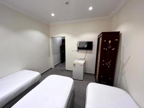 a hotel room with two beds and a tv at فندق الفيروز مكة 3 in Makkah