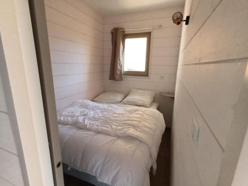 1 dormitorio pequeño con 1 cama en una casa pequeña en location Appartement Bonascre toutes saisons, en Ax-les-Thermes