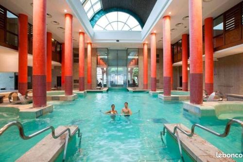 dwoje ludzi pływających w basenie w budynku w obiekcie location Appartement Bonascre toutes saisons w mieście Ax-les-Thermes