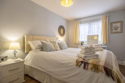 a bedroom with a white bed with towels on it at The Mews in Goudhurst