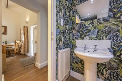 a bathroom with a sink and a wall at The Mews in Goudhurst