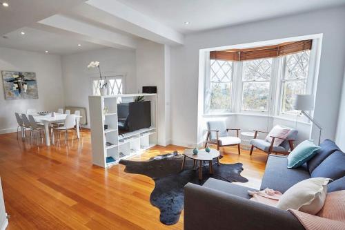 a living room with a couch and a dining room at Large Two Bedroom Apartment with City Park and Bay views in Melbourne