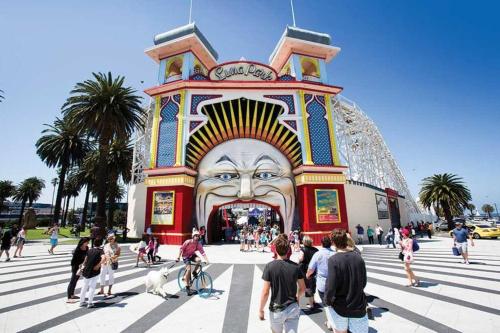 a group of people standing in front of a building with a large face at Large Two Bedroom Apartment with City Park and Bay views in Melbourne