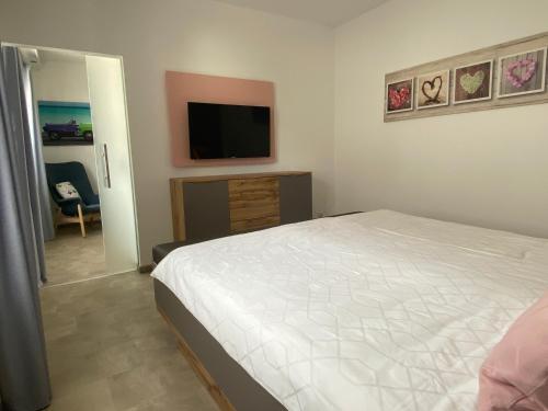 a bedroom with a bed and a flat screen tv at Ferienwohnung Junglen an der Mosel in Zeltingen-Rachtig
