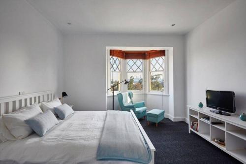 um quarto com uma cama, uma televisão e uma cadeira em Large Two Bedroom Apartment with City Park and Bay views em Melbourne