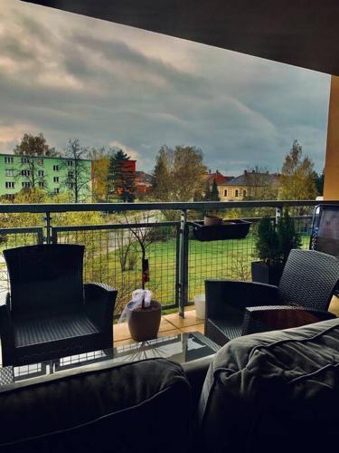 a balcony with chairs and a view of a field at Apartmán s terasou in Tábor